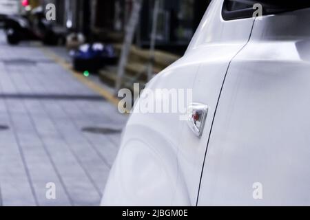 Nahaufnahme des Seitensignals (Blinker, Fahrzeugbeleuchtung), das von der Seite aus auf der linken Seite des Fahrzeugs angebracht ist. Stockfoto