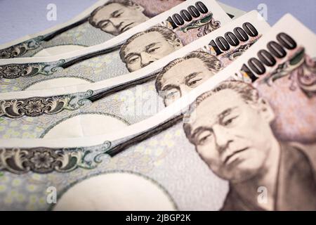 Nahaufnahme der japanischen 10000-Yen-Banknoten auf dem Tisch. Das Bild konzentriert sich auf Yukichi Fukuzawa und seine Augen auf Notizen. Stockfoto