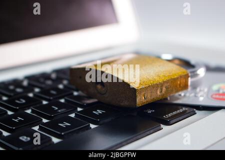 Schloss (Vorhängeschloss) und Kreditkarte auf dem Laptop-Computer. Stockfoto