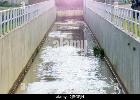 Breiter und tiefer Abflusskanal in der Stadt, für Sturmabwässer Stockfoto