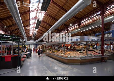 In der überdachten Markthalle in Colmar kaufen die Menschen in der Obst- und Gemüseabteilung ein. Lokale und Bio-Produkte Stockfoto