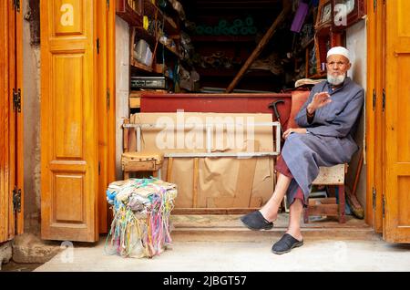 Marokko Fez. Ein alter Mann in seinem Second Hand Shop in der Medina Stockfoto