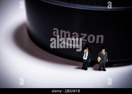 Miniaturleute Geschäftsleute, die vor Amazon Echo Dot stehen. Amazon Echo (auch bekannt als Alexa) ist eine Marke von intelligenten Lautsprechern von Amazon. Stockfoto