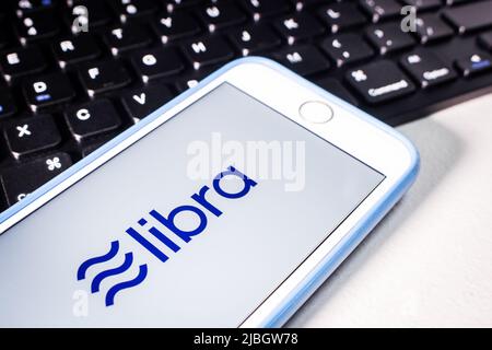 Kumamoto, Japan - Nov 26 2019 : das Logo von Libra, einer digitalen Blockchain-Währung von Facebook, Inc., auf einem iPhone-Bildschirm mit Tastatur auf weißem Tisch. Stockfoto