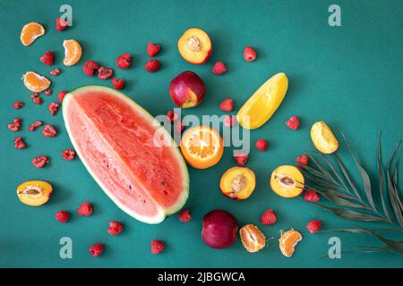 Tropische Früchte auf blauem Hintergrund, flach liegend. Stockfoto
