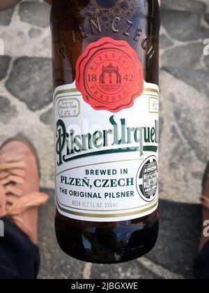 Die Flasche Pilsner Urquell, tschechisches Lager, gebraut von der Pilsner Urquell Brauerei in Pilsen, in meiner Hand. Es ist bekannt als das erste blasses Lager Stockfoto