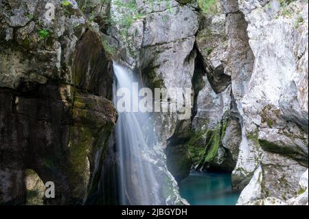Verschwommenes Bild eines schönen Wasserfalls in der großen Schlucht des smaragdgrünen Flusses Soca, slowenien. Stockfoto