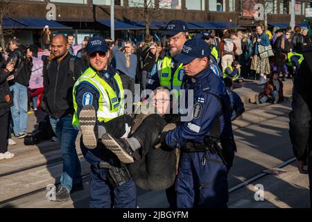 Demonstranten, die von Polizisten bei der Blockierungsdemonstration von Elokapina in Mannerheimintie, Helsinki, Finnland, verhaftet und weggebracht wurden. Stockfoto