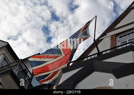 Ein großer Tuchheber von unten gesehen, der an einem sonnigen Tag im Wind fliegt. Konzept für Großbritannien, verblassende Stärke, glorreiche Tage Stockfoto