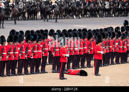 Der Soldat in Uniform wird während der Probe der Trooping the Colour Militärparade ohnmächtig und markiert damit das Platinum Jubiläum von Königin Elizabeth. Stockfoto