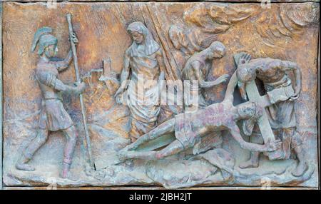MONOPOLI, ITALIEN - 6. MÄRZ 2022: Das bronzene Relief Jesus wird von Wolfgang Stempfele am Kreuz am Tor der Kirche Chiesa di Sacro Cuore genagelt. Stockfoto