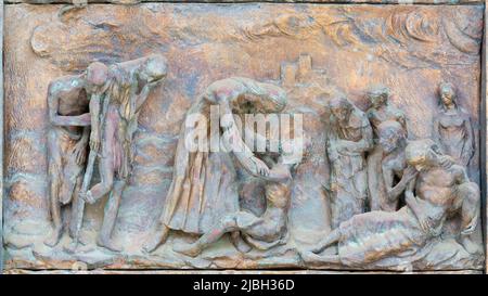 MONOPOLI, ITALIEN - 6. MÄRZ 2022: Das bronzene Relief Jesus bei der Heilung am Tor der Kirche Chiesa di Sacro Cuore von Wolfgang Stempfele. Stockfoto