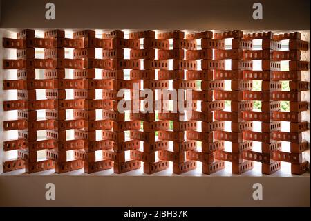 Innen aus orangefarbenem Ziegelstein, in der Wand gestapelt, mit Sonnenlicht Stockfoto