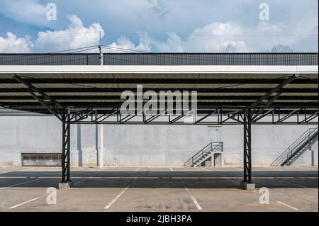 Parkplatzschlitz mit Metalldach und Lagerverteilung im Hintergrund Stockfoto