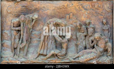 MONOPOLI, ITALIEN - 6. MÄRZ 2022: Das bronzene Relief Jesus bei der Heilung am Tor der Kirche Chiesa di Sacro Cuore von Wolfgang Stempfele. Stockfoto