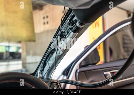 Installation des Drahtes der Dashcam oder des Videokameras-Recorders in der Autowerkstatt Stockfoto