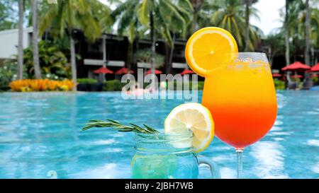 Familienspaß im Urlaub. Zwei Gläser mit tropischen, farbenfrohen Getränken am Pool Stockfoto