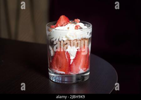 Dessert mit Erdbeeren und Rahm. In einem Glasgefäß. Nahaufnahme. Stockfoto