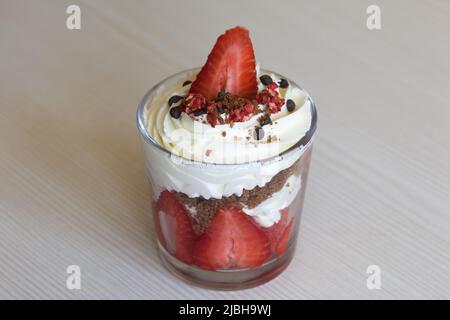 Dessert mit Erdbeeren und Rahm. In einem Glasgefäß. Nahaufnahme. Stockfoto