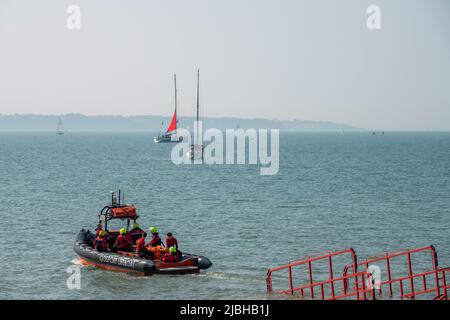 Rettungsboot wird mit einem Traktor in der Stokes Bay Hampshire England ins Meer gestartet Stockfoto