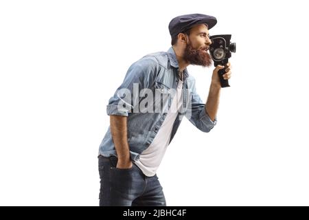 Profilaufnahme eines Mannes, der mit einer isolierten Vintage-Kamera aus dem Jahr 8mm auf weißem Hintergrund aufgenommen wurde Stockfoto