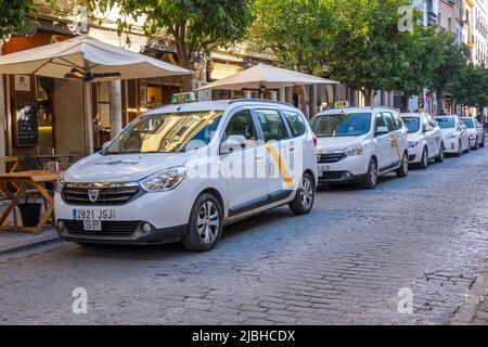 White Taxi Taxis Reihen sich an Einer Straße in Sevilla an Spanien Tele Taxi Service Dacia Lodgy Minivan Taxis Stockfoto