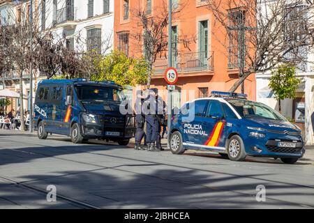 Nationales spanisches Polizeikorps (CNP), Beamte zwischen Einem Polizeiauto und einem Polizeiwagen im Stadtzentrum von Sevilla, Spanien, Policia Nacional Spanien Stockfoto