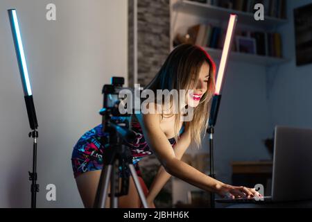 Eine Trainerin streamt eine Online-Sitzung zu Hause mit ihrem Computer Stockfoto