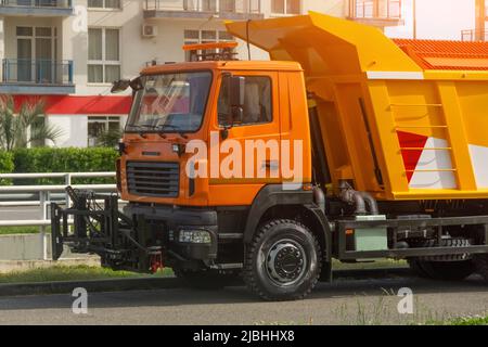 Orange spezielle Reinigungsdienste Erntewagen mit einem umgewandelten austauschbaren Werkzeug in der Vorderseite Stockfoto