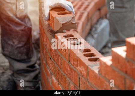 Maurer arbeiten an einer gebogenen Wand Stockfoto