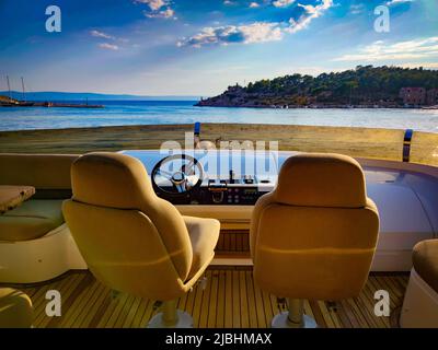 Fahren auf einer Luxusyacht am Mittelmeer in Kroatien. Zwei Sitze, Lenkrad und Bedienfeldtasten. Stockfoto