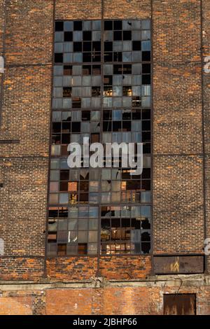 Ruinen einer verlassenen Industrieanlage. Backsteinwände mit großen Fenstern. Foto aufgenommen an einem sonnigen Tag. Stockfoto