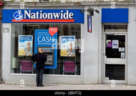 Warminster, Wiltshire, Großbritannien - 12 2014. Oktober: Eine Frau zieht Bargeld von einem Geldautomaten der Nationwide Building Society in Warminster, Wiltshire, England, Großbritannien, ab Stockfoto