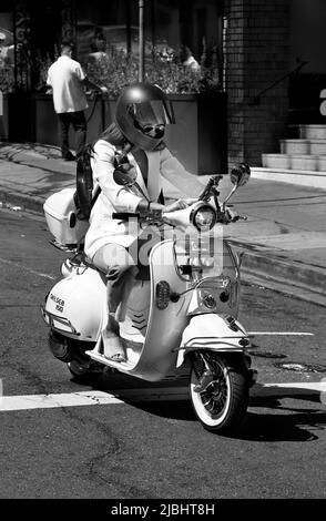 Eine Frau auf einem BMS Chelsea 150 Roller hält an einer Ampel in San Fancisco, Kalifornien, inne. Stockfoto