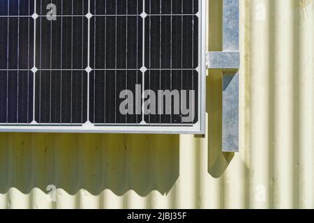 Vom Netz leben. Sonnenkollektoren liefern Strom für ein aus Wellblech erbautes Haus im neuseeländischen Backcountry. Stockfoto