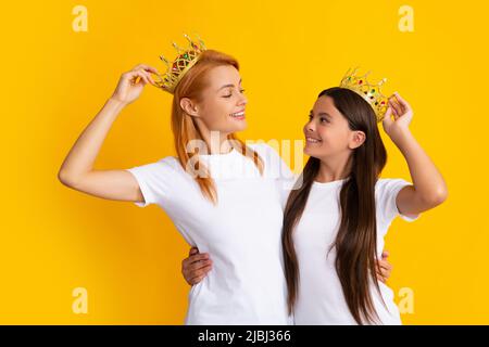 Königinnen in Tiara. Lustige Familie auf gelbem Hintergrund. Mutter und Tochter Mädchen mit Krone. Zwei Prinzessin. Stockfoto