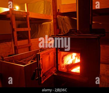 Typischer Holzofen im Bunkerraum einer Department of Conservation Hütte, Aotearoa / Neuseeland Stockfoto