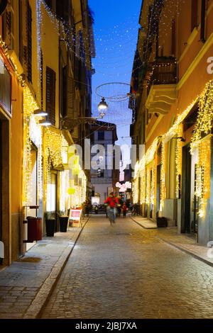 Blick auf Gassen mit weihnachtlicher Beleuchtung in der Nacht von Parma in Italien Stockfoto