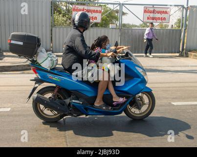 SAMUT PRAKAN, THAILAND, MÄRZ 19 2022, Ein Mann mit einem kleinen Mädchen fährt ein Motorrad. Stockfoto