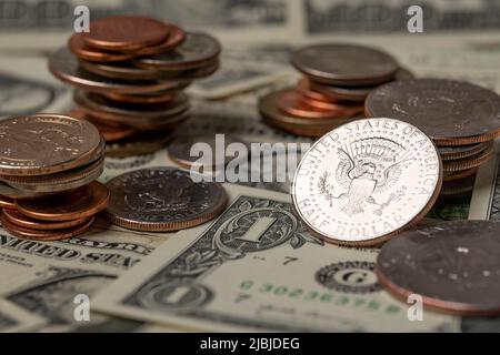 Stapelte Dollarmünzen auf 1-Dollar-Banknoten auf. US-Dollar in bar, Rechnungen bezahlen und Trinkgeld geben. Investitionen in die Wirtschaft. Ein halber Dollar glänzt Stockfoto