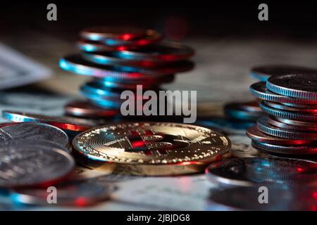 Goldbitcoin neben Dollarmünzen und Banknoten. US-Dollar-Bargeld stapelte Münzen und Papiergeld als Hintergrund auf. Krypto-Währung und Blockchain-Technologie Stockfoto