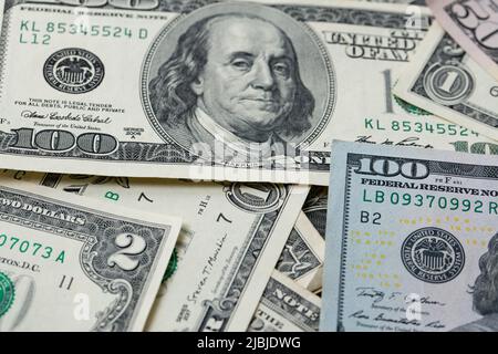 Dollarnoten verteilen sich. Ein bis hundert Dollar Banknoten, selten zwei Dollar dazwischen. Hintergrund mit US-Dollar-Banknoten. Ca Stockfoto