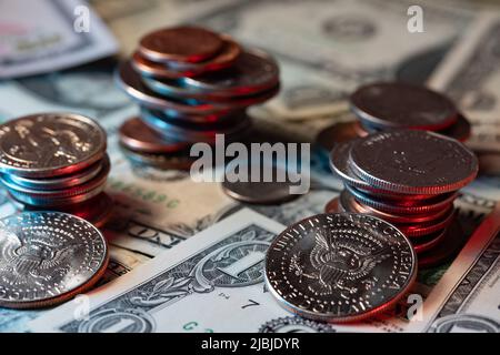 Auf den 1-Dollar-Banknoten stapelten sich Dollarmünzen. Riesige Münzen von Groschen bis hin zu einer halben Dollar-Münze Stockfoto