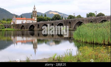 Mittelalterliche Steinbrücke über den Fluss Lima, Kirche Santo Antonio da Torre Velha aus dem 18.. Jahrhundert auf der gegenüberliegenden Flussseite, Ponte de Lima, Portugal Stockfoto