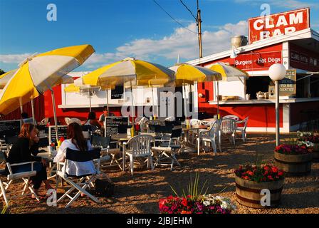 Leute genießen einen sonnigen Sommertag, wenn sie im Freien in einer Muschel-Bar in den Hamptons auf Long Island essen Stockfoto