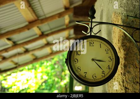 Große alte Uhr an der Wand des Steinhauses in der Natur Stockfoto