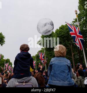 London, Greater London, England, 04 2022. Juni: Jubilee Concert at the Mall. Jungen sitzen auf den Schultern, während die Leute versuchen, den Ball die Straße hinunter zu schlagen. Stockfoto