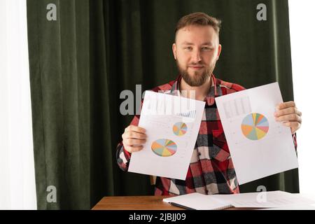 Porträt eines ernsthaften Geschäftsmannes, der im Büro Finanzdaten und -Dokumente mit Diagramm und Grafik lernt. Betriebswirtschaftliche Rechnungslegung Konzept, Budget und Darlehen Stockfoto