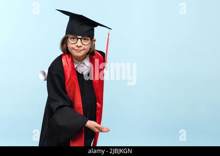 Whizz Kid 9-11 Jahre Mädchen trägt Abschlusskappe, runde Brillen und Zeremonie Robe mit Zertifikat Diplom auf hellblauem Hintergrund. Abschlussfeier Stockfoto