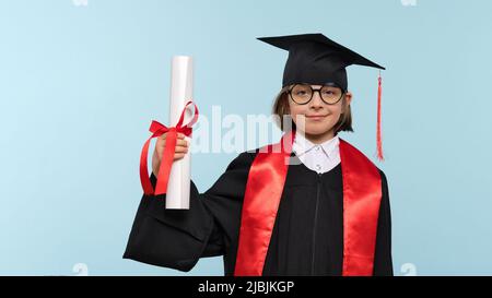 Whizz Kid 9-11 Jahre Mädchen trägt Abschlusskappe, runde Brillen und Zeremonie Robe mit Zertifikat Diplom auf hellblauem Hintergrund. Abschlussfeier Stockfoto